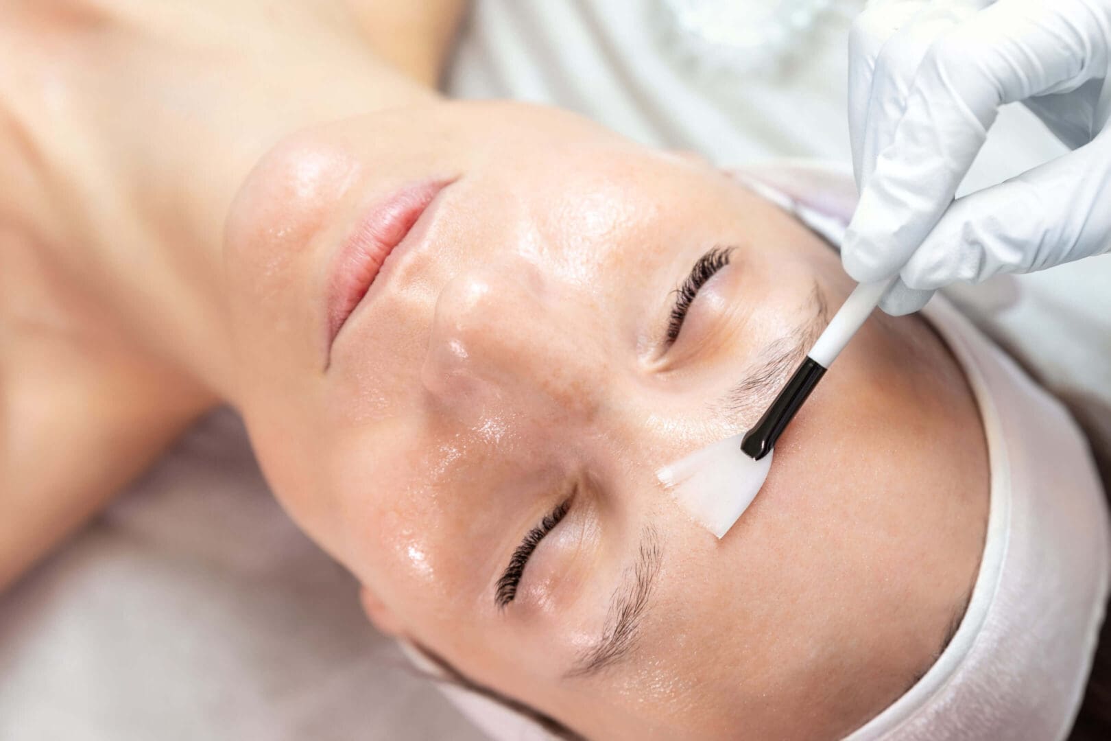 Facial treatment with brush on forehead.