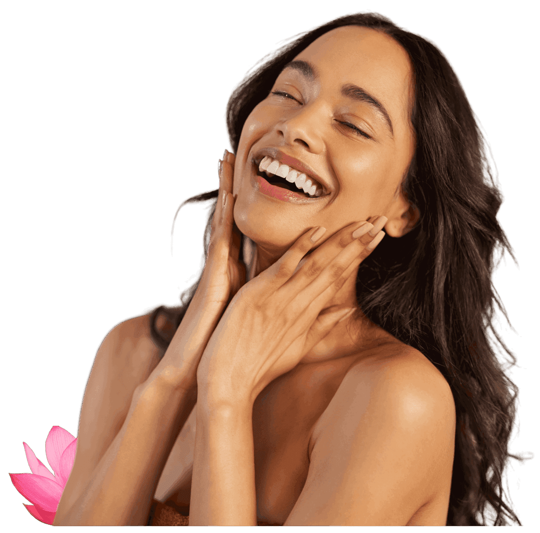 Joyful woman with glowing skin smiling and touching her face.