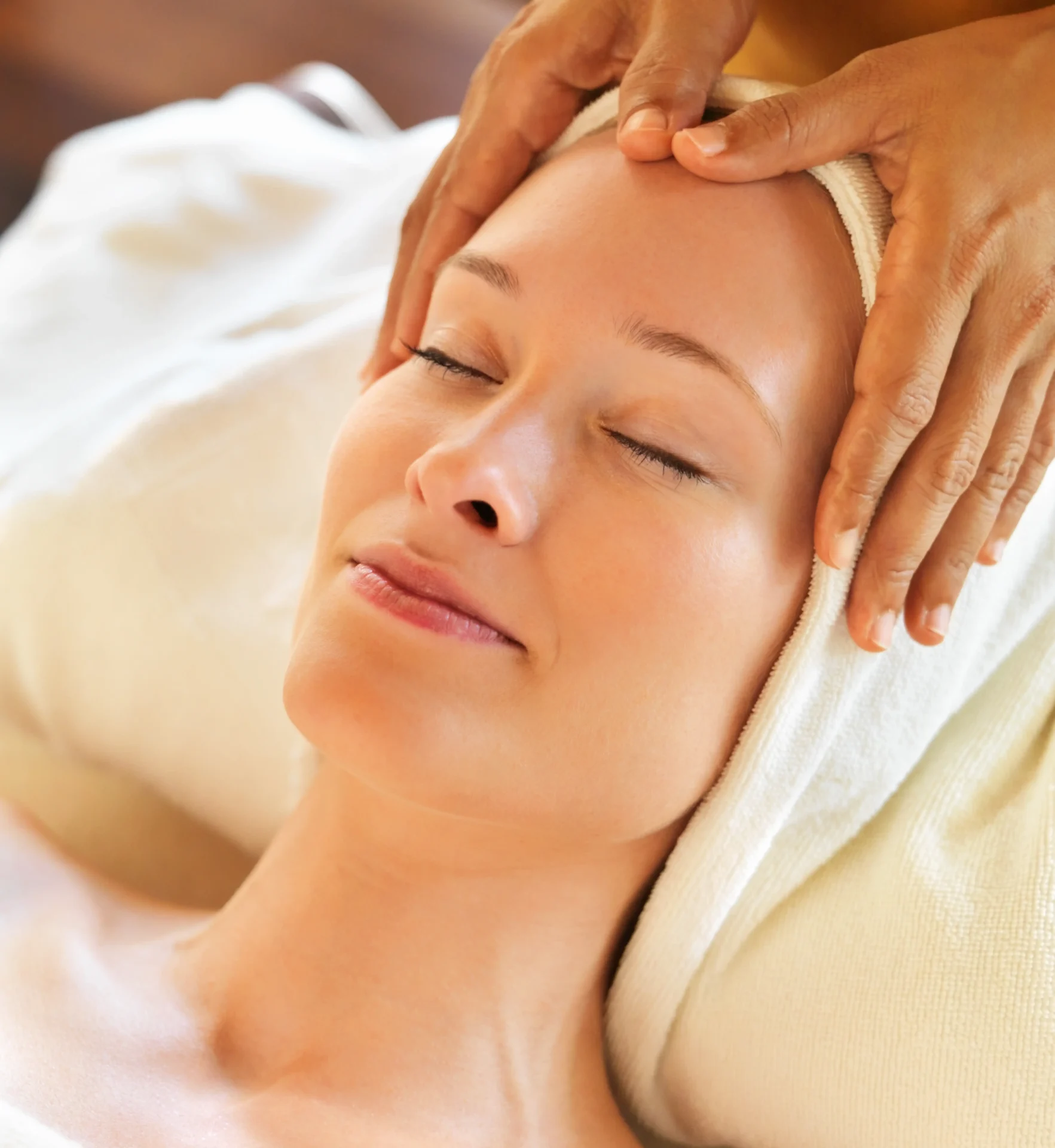 Relaxed woman receiving facial massage
