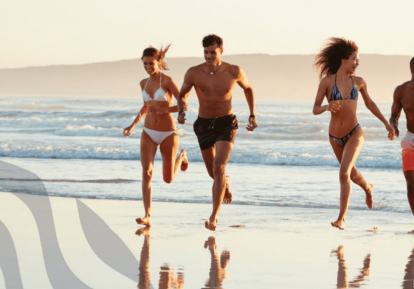 Group running on a sunny beach.